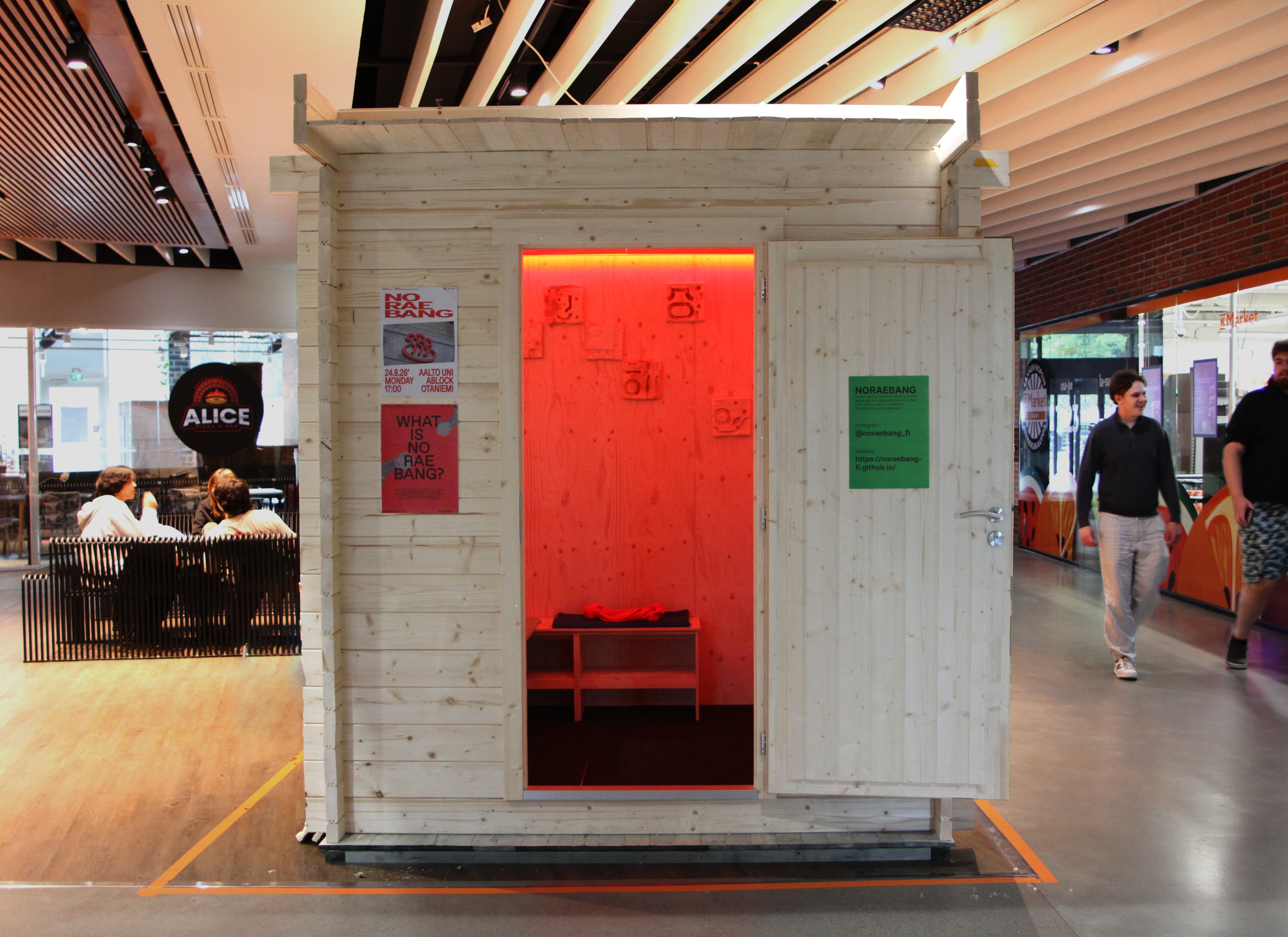 Photo of noraebang booth with red light shining from inside and front door wide open.